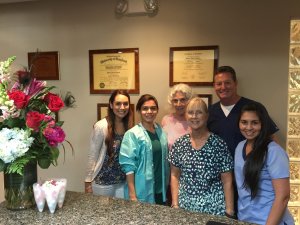 Dr. Eggnatz pictured with his staff and a recent DDS patient. 