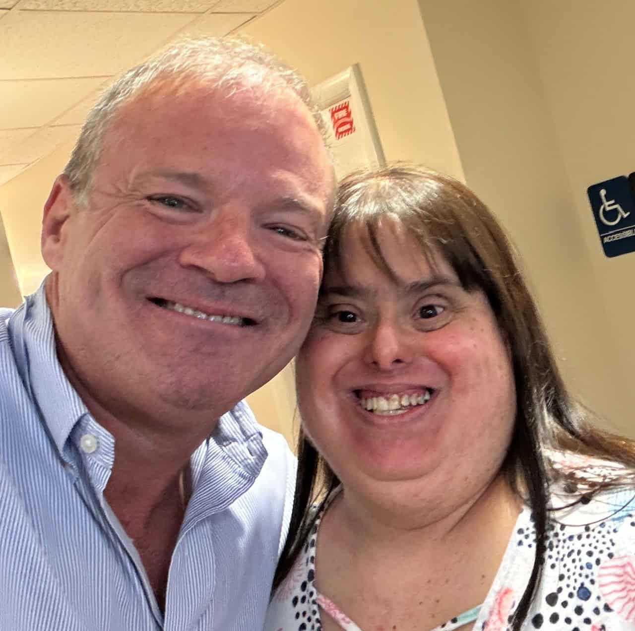 Volunteer dentist smiles with DDS patient after completing treatment.